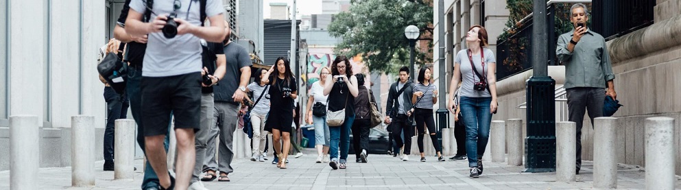 Banner image of pedestrians with cameras.