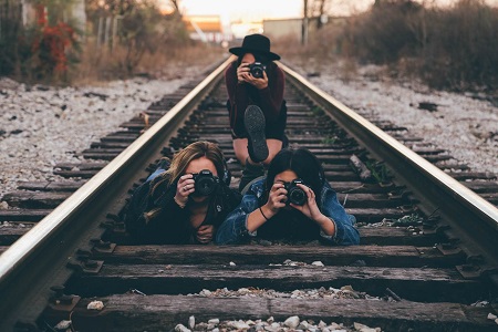 Image of three people with cameras on a railway.